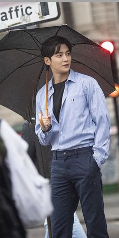 a man walking down the street holding an umbrella