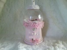 a snow globe with pink flowers and a tiara hanging from it's top