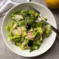 a salad with radishes and other vegetables in a white bowl on a table