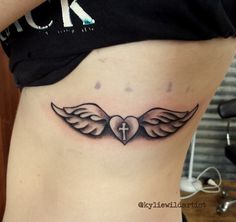 a woman with a cross and wings tattoo on her stomach