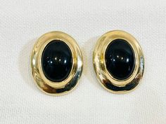 "Bold black and golden oval earrings from the Eighties! Black stone in the center (most likely plastic) with shiny gold tone metal setting. Thick wire clip on backing, as opposed to the usual style clip found on these types of earrings. Signed \"LC\" on the back for Liz Claiborne. In good vintage condition. Simply designed with a lot of style! Measurements Height: about 1 1/8\" Width: slightly over 7/8\" Please contact us with any questions. International shoppers, please contact us for a shipping quote." Classic Oval Clip-on Earrings, Classic Oval Cabochon Clip-on Earrings, Luxury Clip-on Oval Cabochon Earrings, Black Oval Vintage Earrings, Gold Oval Cabochon Clip-on Jewelry, 80s Jewelry, Types Of Earrings, Oval Earring, Bold Black