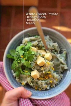 a person holding a blue bowl filled with food and garnished with cilantro