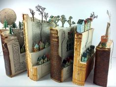 several books are stacked on top of each other with houses and trees in the pages