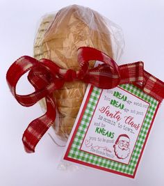 a bagel wrapped in plastic and tied with a red ribbon next to a packaged package