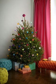 a small christmas tree sitting on top of a wooden floor in front of a window