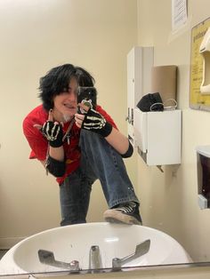 a man taking a selfie in front of a bathroom mirror with his hands up