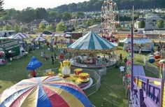 an aerial view of a fairground with many rides and carnival booths in the background