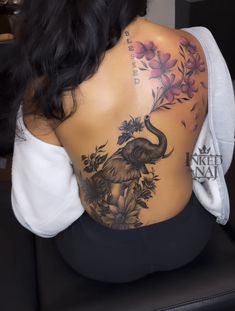 the back of a woman's body with an elephant tattoo on her lower back