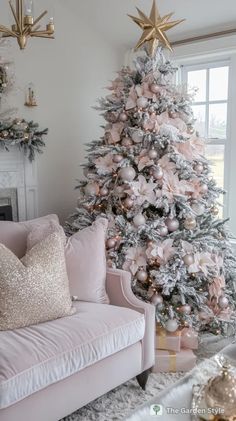 a pink christmas tree in a living room with gold and silver ornaments on the top