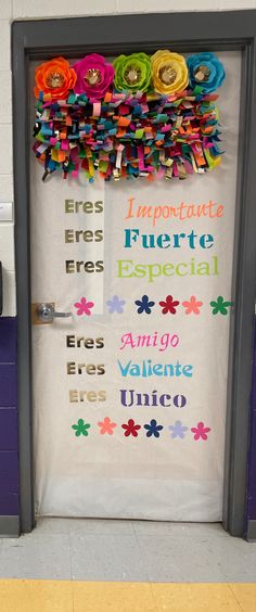 a door decorated with colorful paper flowers and sayings for the spanish language students to use