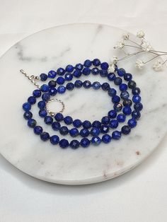 "Details: ☆ Gemstone- High quality Natural Lapis Lazuli, faceted round shape, 5mm  ☆ Closure- 925 Sterling silver, 12mm, a toggle clasp, twisted round ☆ Bead tip- 925 Sterling silver, 3mm ☆ Bead cap- 925 Sterling silver, 3mm, flower shape  The necklace length is 18.25\". It looks beautiful alone or layered with other necklaces.  It is a perfect gift for someone special or yourself.    All my jewelries are made with lots of love and care. Lapis Lazuli: Lapis Lazuli has many healing properties. This pretty indigo and gold gemstone is known for cleansing the throat and third eye Chakras and can be used to ward off physical attacks. As a stone geared towards wisdom and communication, Lapis Lazuli can also help connect you to clarity, integrity, and intuition." Sterling Silver Crystal Necklace With Gemstone Beads, Sterling Silver Faceted Round Bead Necklaces, Sterling Silver Crystal Necklace With Round Beads, Sterling Silver Faceted Round Beads Necklace, Beaded Necklace With Sterling Silver Clasp As Gift, Sterling Silver Necklace With Faceted Round Beads, Faceted Round Bead Sterling Silver Necklace, Sterling Silver Necklaces With Faceted Beads, Sapphire Faceted Beaded Necklace For Gift