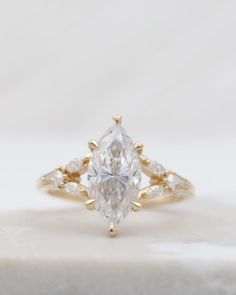 an engagement ring with a pear shaped diamond in the center and side stones around it