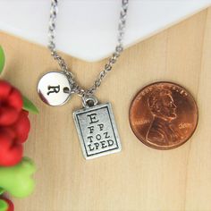 ♥ Eye Care Necklace Silver Eye Chart Charm Necklace Vision Pendant Eye Doctor Charms Optometry Jewelry Initial Necklace Eye Doctor Gift Monogram ♥ This is a beautiful Eye Care charm with hand stamped initial charm on a stainless steel chain, You able to choose initial from a drop down menu, ♥ You will receive 1 necklace ♥ Eye Doctor charm19x10 mm ♥ Initial charm 10 mm choose from a drop down menu ♥ Stainless steel chain 18 inches ♥ additional initial https://www.etsy.com/listing/766732811 If you Personalized Rectangular Metal Jewelry, Stamped Metal Necklaces For Gifts, Vintage Personalized Silver Charm Necklace, Vintage Style Personalized Silver Charm Necklace, Personalized Vintage Silver Charm Necklace, Nickel-free Metal Charm Necklaces As Gift, Rectangular Charms Jewelry For Personalized Gift, Personalized Rectangular Charms Jewelry, Personalized Engraved Metal Charm Necklace