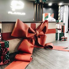 several wrapped presents sitting on top of each other in front of a sign that says christmas