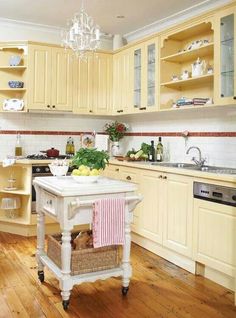 a kitchen with wooden floors and yellow cabinets