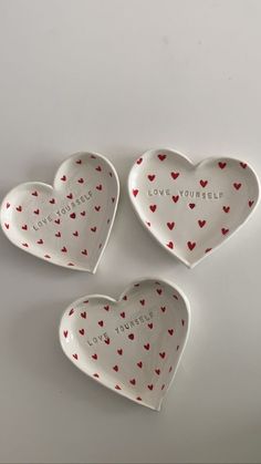 three heart shaped dishes with the words love and cherries written on them in red hearts