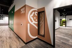 an empty room with wooden flooring and walls painted in brown, white and green