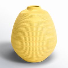 a yellow vase sitting on top of a white table