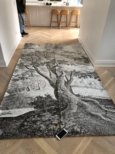 a large rug with a tree on it in the middle of a room next to a counter