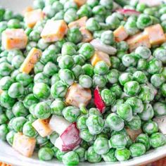 a white bowl filled with peas and carrots