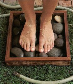 a person standing on top of rocks in a wooden box with the words foot wash station