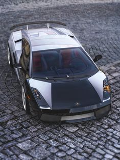 a silver and black sports car on cobblestone road