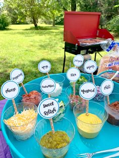 a blue tray topped with lots of food on top of a table next to a fire pit