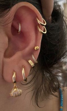 a woman with ear piercings and gold rings