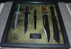 several knives are displayed in a shadow box