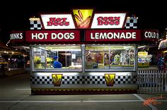 a hot dog stand is lit up at night