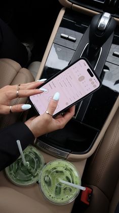 a woman holding an iphone in her car