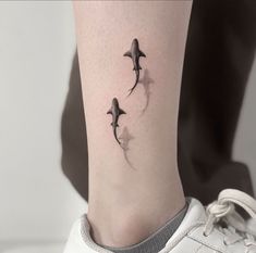 three dolphins swimming together on the ankle tattoo designs for women and men are shown in black ink