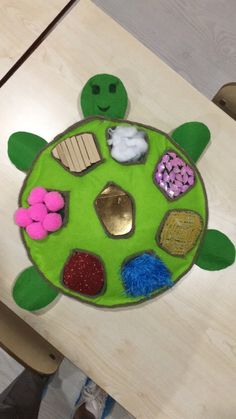 a child's table with a turtle made out of felt and other things on it