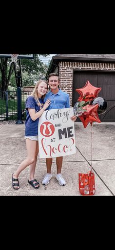 a man and woman standing next to each other holding a sign