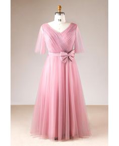 a dress on a mannequin with a pink bow at the waist and sleeves