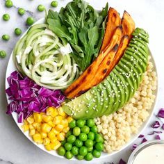 a white plate topped with different types of vegetables next to a bowl of peas and carrots