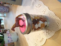 a glass jar filled with candy and a horse figurine on top of it