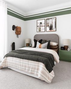 a bedroom with two pictures on the wall above the headboard and nightstands in front of the bed