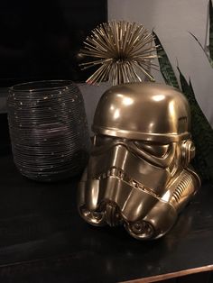 a star wars helmet sitting on top of a black table next to potted plants