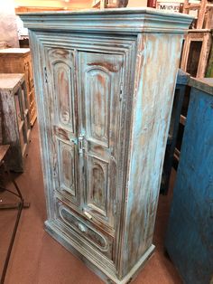 an old blue armoire sitting in a room