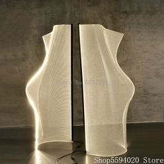 a lamp that is sitting on top of a table in front of a concrete wall