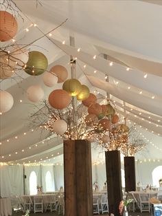 the inside of a tent decorated with lights and paper lanterns