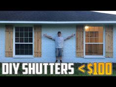 a man standing in front of a blue house with shutters on it's windows