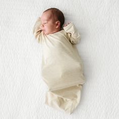 Child laying on a bed wearing a Heather Oatmeal Ribbed Infant Gown Matching Hospital Gown And Swaddle, White Nursing-friendly Sleepwear, Baby Sleeper Gown, Matching Sibling Outfits, Spring Nursing-friendly Long-sleeve Sleepwear, Newborn Fashion, Cotton Long Sleeve Nursing-friendly Sleepwear, Pet Stockings, Sibling Outfits