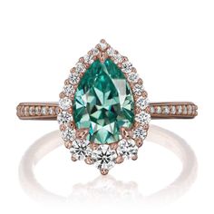 a green and white diamond ring with diamonds around it