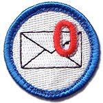 a blue and white patch with a pink letter on it's center, in the shape of an envelope