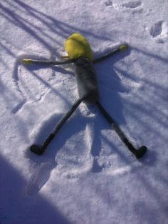 a toy is laying in the snow on it's back legs and feet,