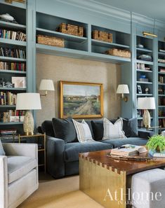 a living room filled with lots of furniture and bookshelves covered in blue bookcases