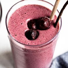 a close up of a smoothie with cherries in it