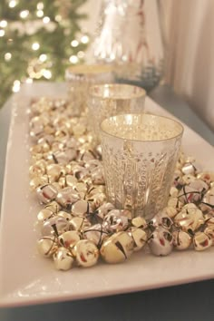 a table topped with lots of glass cups and christmas decorations on top of it's tray